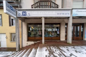 Devanture extérieure de l'agence de pompes funèbres Metzinger sous la neige.